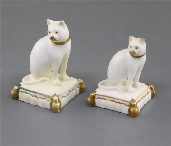 Two Rockingham porcelain figures of a cat seated on a tasselled cushion, c.1830, 5.5cm and 6.4cm, largest restored